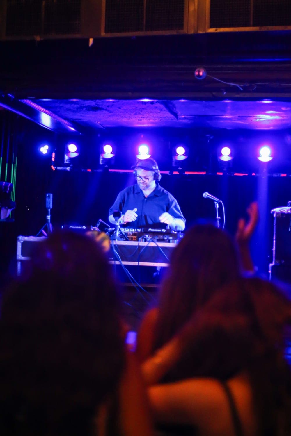 Crowd with hands up under blue stage light at Subterranean, Chicago, compil3r opening for MONIC, July 2026